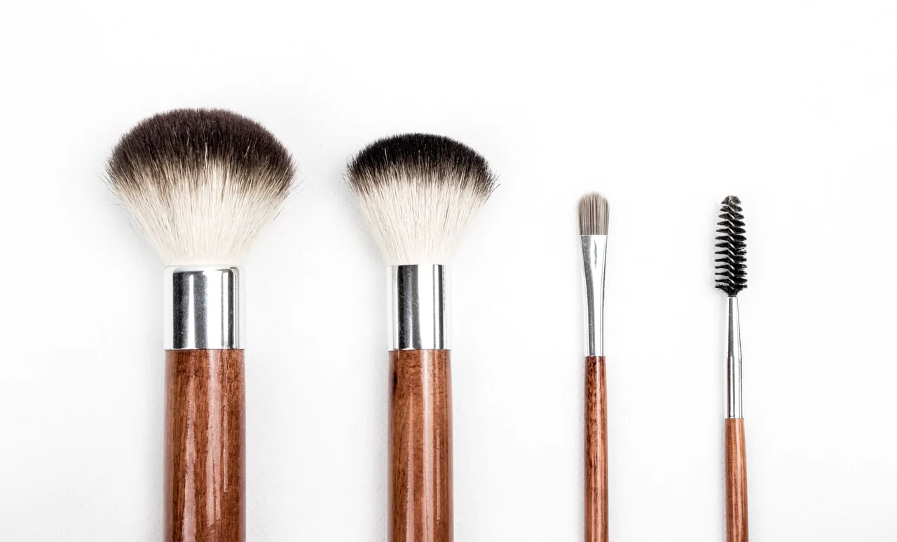 Makeup brushes and a spoolie with wooden handles on a white background